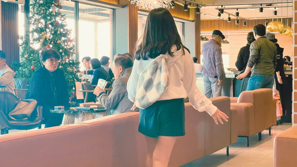 やわらかい陽ざしが差し込む釜山のベーカリーカフェ店内を歩く女の子の後ろ姿。